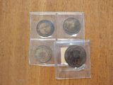 four different types of coins are in small plastic bags on a wooden surface