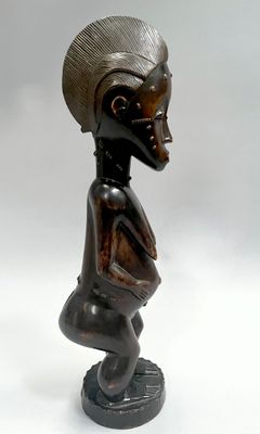statue d'une femme assise sur un tabouret, coiffée d'un chapeau