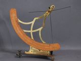 un objet en bois et en laiton posé sur un socle métallique