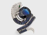 une photo d'une broche en forme de serpent, sertie de saphirs et de diamants