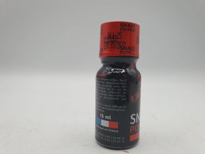 un gros plan d'une bouteille contenant un liquide posée sur une surface blanche