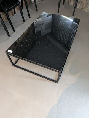 une table en verre sur laquelle est posé un livre, au milieu d'une pièce
