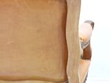 a wooden chair with a brown leather seat and arm rest