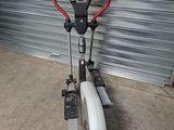 un vélo d'appartement dans un garage, avec un guidon rouge