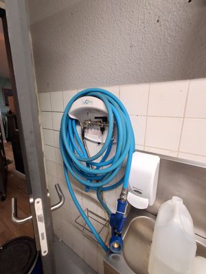 un tuyau bleu accroché au mur à côté d'un évier