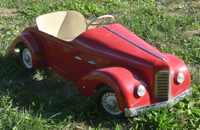 a red toy car that is sitting in the grass