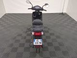 a motor scooter parked in a room with a checkered floor