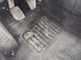 a dirty floor in a car with two pedals on it