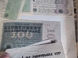 a person holding a piece of paper in front of a pile of old money