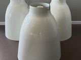 trois vases blancs posés sur une table dans une pièce