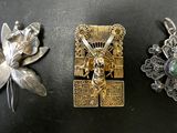 trois pendentifs en argent et en or sur un fond noir orné d'une fleur