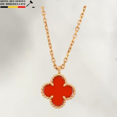 une chaîne en or avec un pendentif en forme de fleur rouge