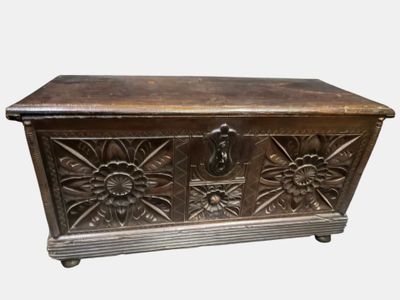 Grand coffre en bois béarnais une façade sculptée de fleurs.
