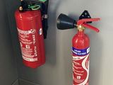 deux extincteurs accrochés au mur l'un à côté de l'autre