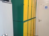 yellow and green lockers in a hallway next to a white refrigerator