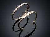 a close up of two gold rings on a black surface