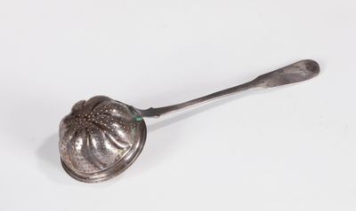 une vieille cuillère en argent avec un manche sur une surface blanche