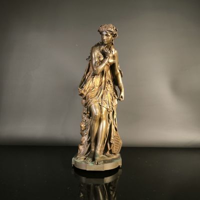 bronze statue of a woman holding a basket of flowers on a black surface