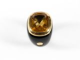 a close up of a gold and black ring with a faceted citrine stone