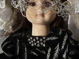 a doll that is wearing a black dress and a veil