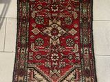 a rug on the floor with a chair next to it