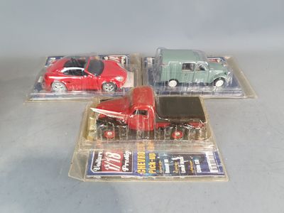 three toy cars in a plastic case on a table