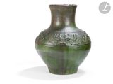 un vase vert posé sur une surface blanche
