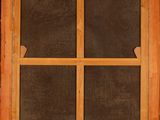 a close up of a window with a wooden frame on a brick wall
