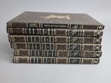 three books stacked on top of each other on a white surface