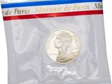 a close up of a coin in a plastic bag on a white background