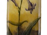 a glass vase with a purple flower inside of it