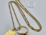 a gold plated ring with a black stone on a chain
