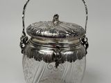 a silver plated jar with a handle and a handle