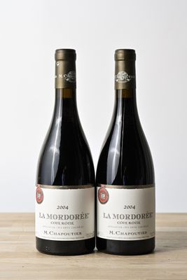 deux bouteilles de vin rouge posées sur une table en bois