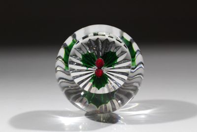 un objet en verre contenant une fleur rouge