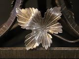 a metal object with a leaf on it sitting on a table