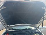 une voiture dont le capot est ouvert et dont le moteur se trouve dans le coffre
