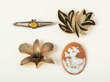 three brooches of various shapes and sizes on a white surface