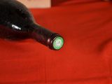 a bottle of wine sitting on a red table cloth
