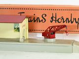 une petite maquette de gare avec un panneau dessus