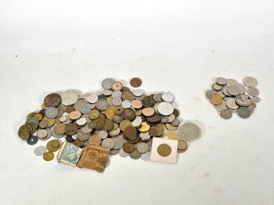 un tas de pièces posé sur une table à côté d'une feuille de papier