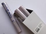 une boîte blanche contenant trois stylos, posée sur une table