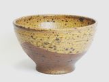 a brown and black bowl sitting on a white surface