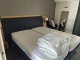 un lit recouvert d'une couverture blanche dans une chambre d'hôtel