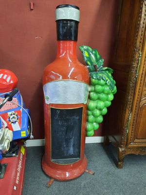 une bouteille de sauce piquante par terre, à côté d'un tas de jouets