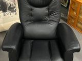 un fauteuil inclinable noir qui se trouve dans une pièce