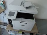 une imprimante blanche posée sur un bureau en bois