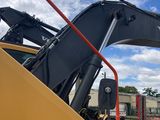 a yellow excavator that is sitting on the side of the road