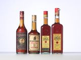three bottles of liquor are lined up on a white surface