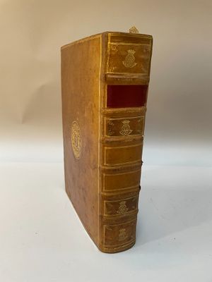 un vieux livre posé sur une table blanche à côté d'un mur blanc